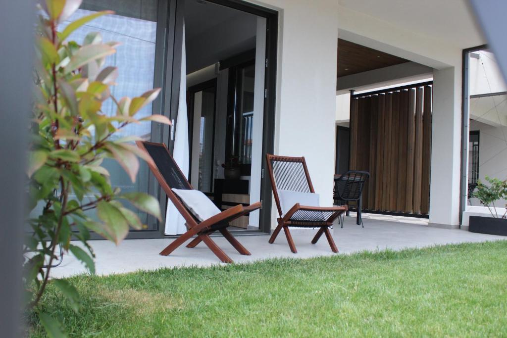 two chairs sitting on the porch of a house at aella apartments in Nikiti