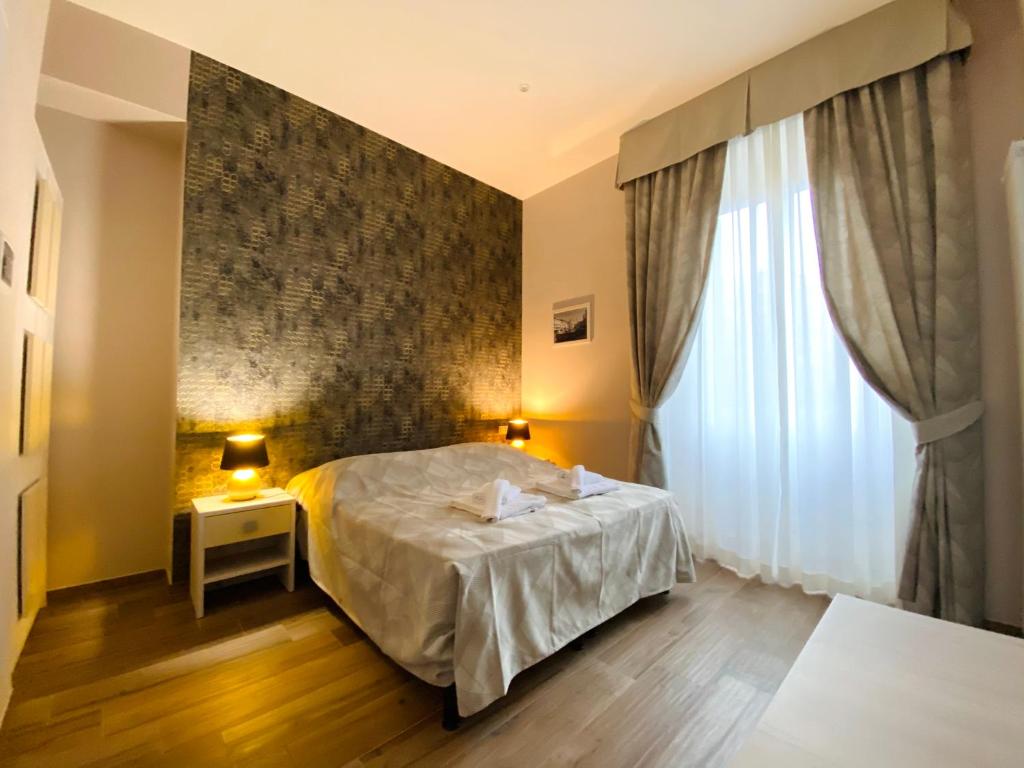 1 dormitorio con cama y ventana grande en Hotelier 51 en Roma