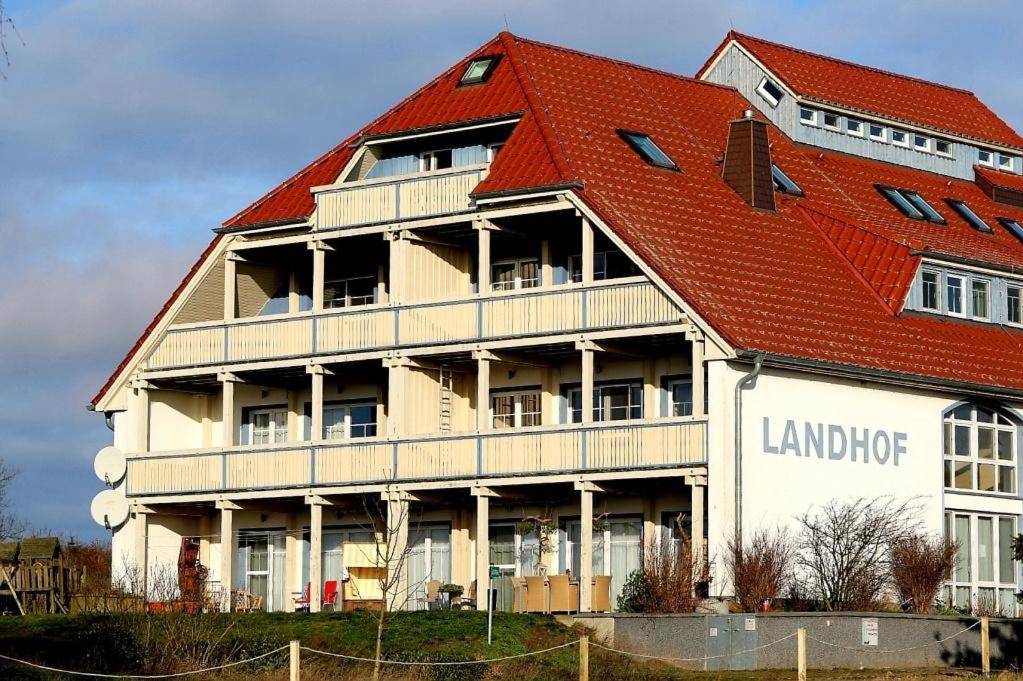 ein großes weißes Gebäude mit rotem Dach in der Unterkunft Der Landhof Weide in Stolpe auf Usedom