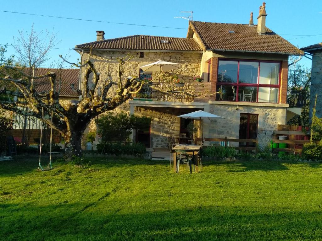 une maison en pierre avec une table dans la cour dans l'établissement Gite d'Antoine, à Saint-Gérons