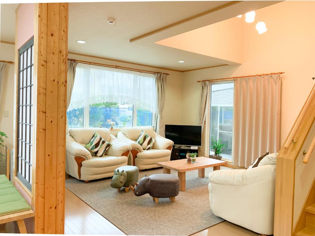 uma sala de estar com um sofá e uma mesa em Ecco's House エッコズハウス em Shiraoi