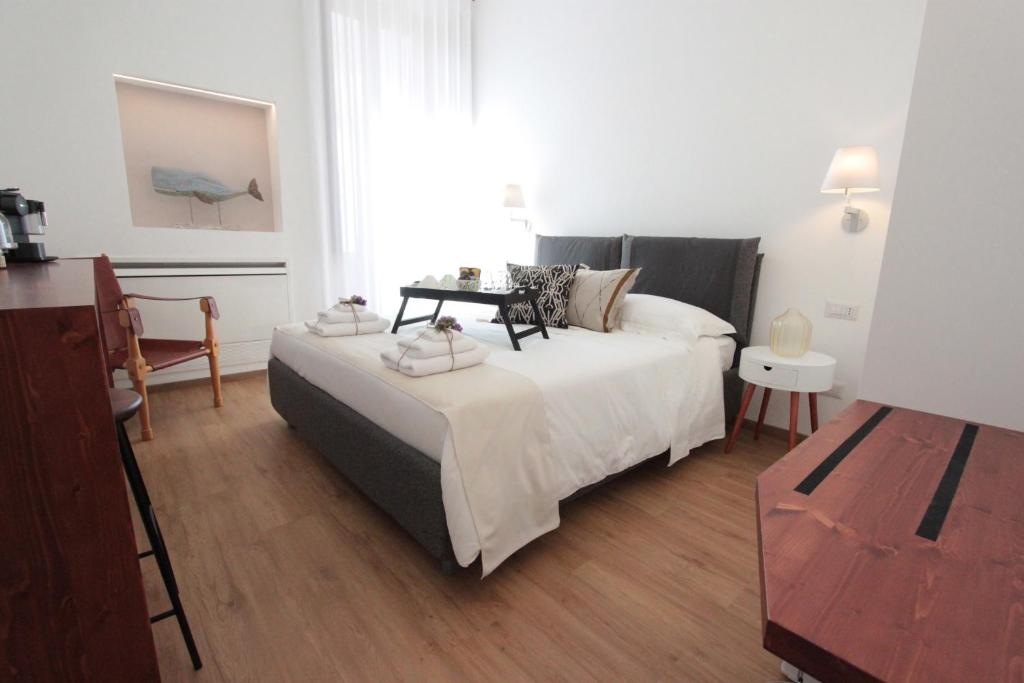 ein Schlafzimmer mit einem Bett und einem Tisch darauf in der Unterkunft Palazzo Pinto B&B - Brindisi (Italy) in Brindisi