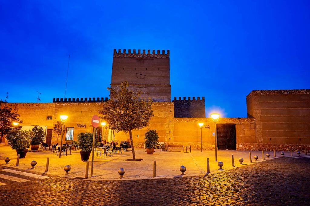 un edificio con una torre encima por la noche en Castillo De Pilas Bonas, en Manzanares