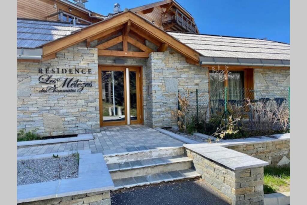 ein Steingebäude mit einem Schild, das ein gläsernes Dorf liest in der Unterkunft Appartement de charme dans résidence avec piscine La Joue du Loup in Le Dévoluy
