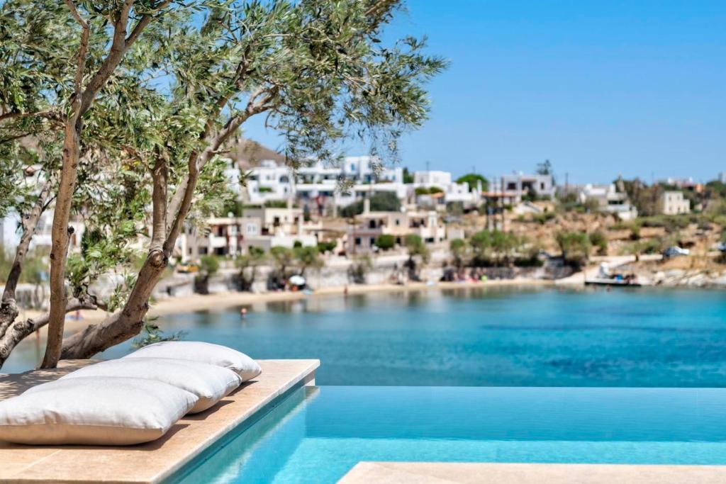 a pool with pillows and a view of a city at Marconi's seaside villa in Megas Gialos - Nites