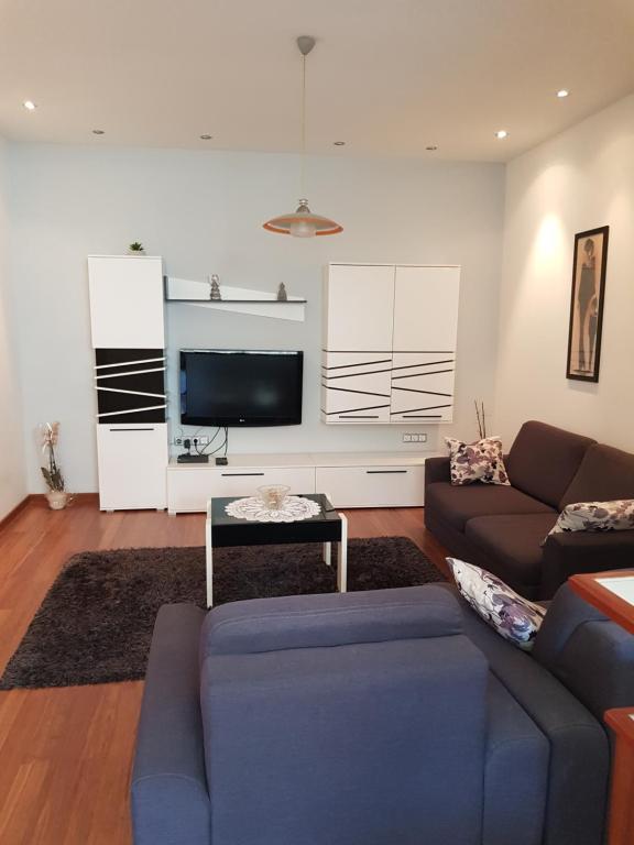 a living room with a couch and a tv at Apartment Centar Omis in Omiš