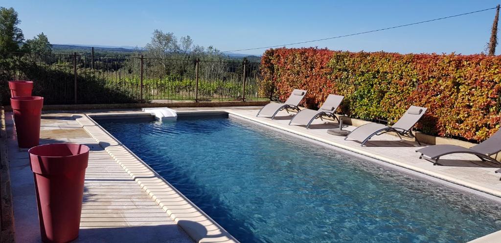 a swimming pool with lounge chairs and a swimming pool at Mas du Tilleul in Beaumes-de-Venise