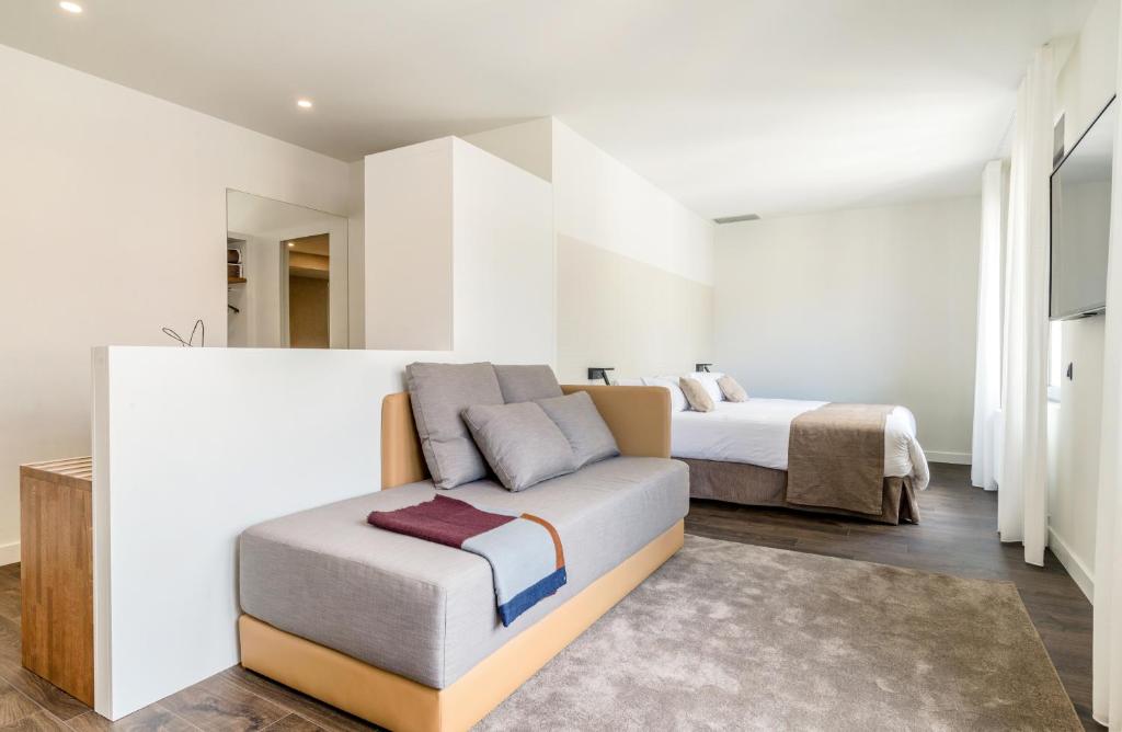 
a hotel room with a bed, chair, and nightstand at Peninsular in Girona
