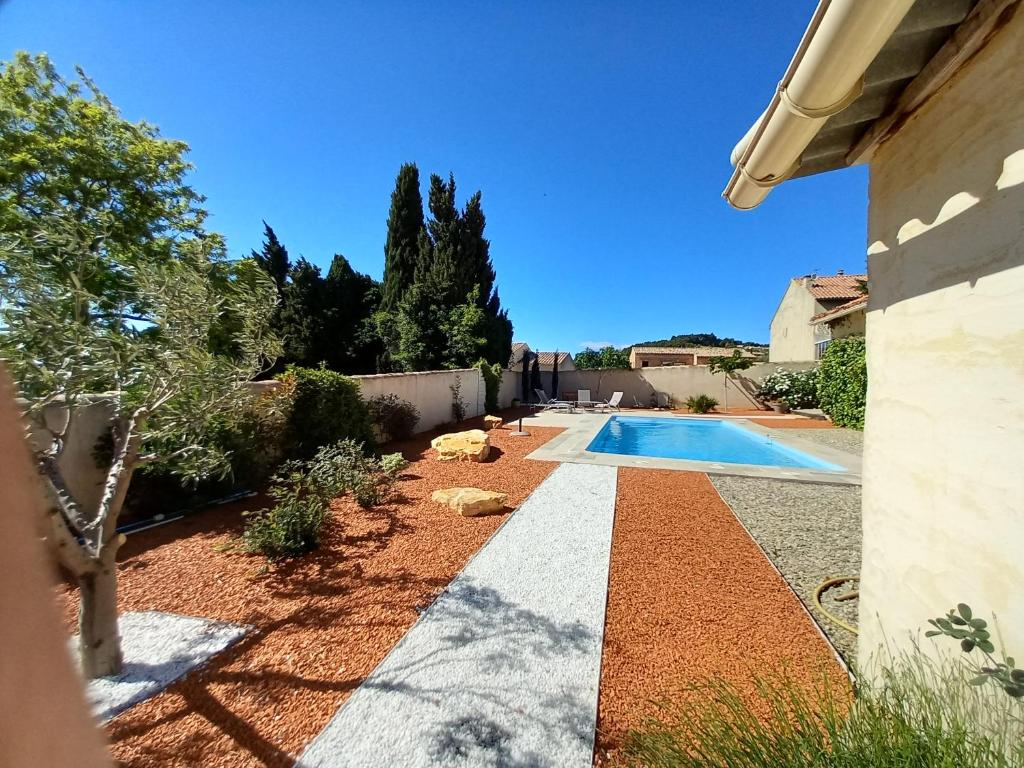 a garden with a swimming pool and a house at Le Clos des Evigneaux in Rasteau