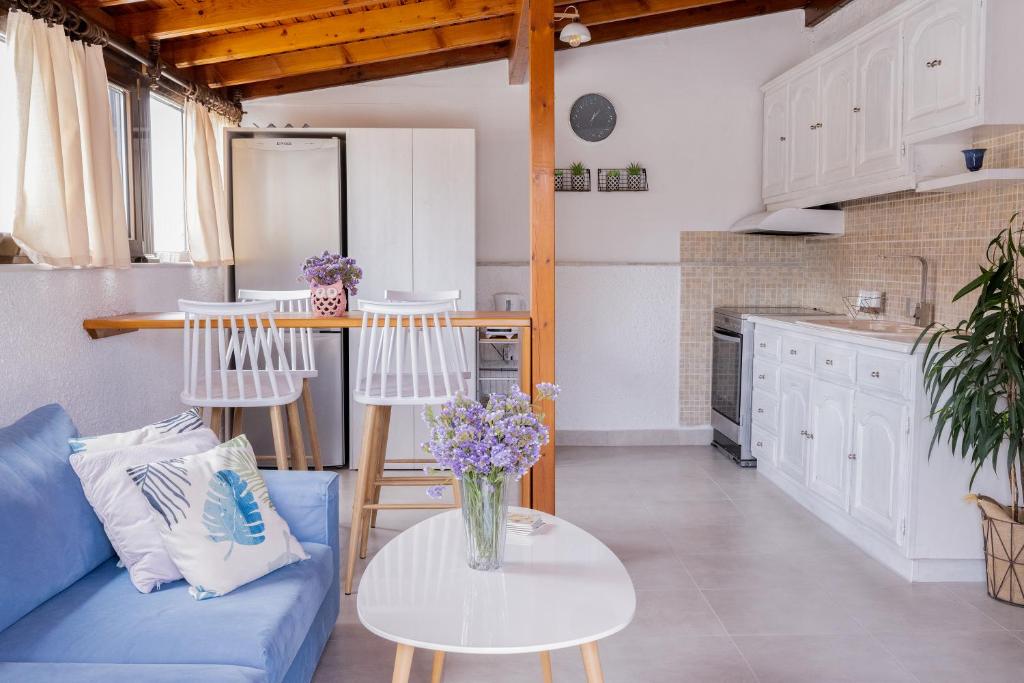 een woonkamer met een blauwe bank en een tafel bij Margarita's House by the beach in Psilí Ámmos