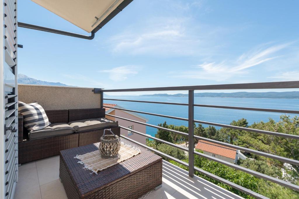 a balcony with a table and a view of the water at Apartments Jadranka in Mimice