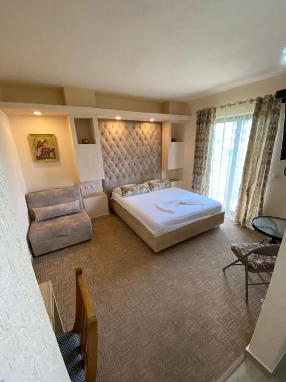 烏爾齊尼的住宿－Guesthouse Liamra，一间卧室配有一张大床和一把椅子