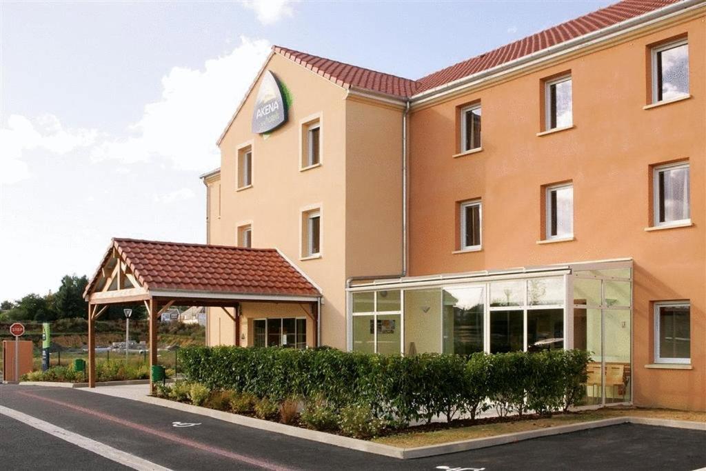 a hotel with a sign on the side of a building at Hôtel Akena City Caudry in Caudry