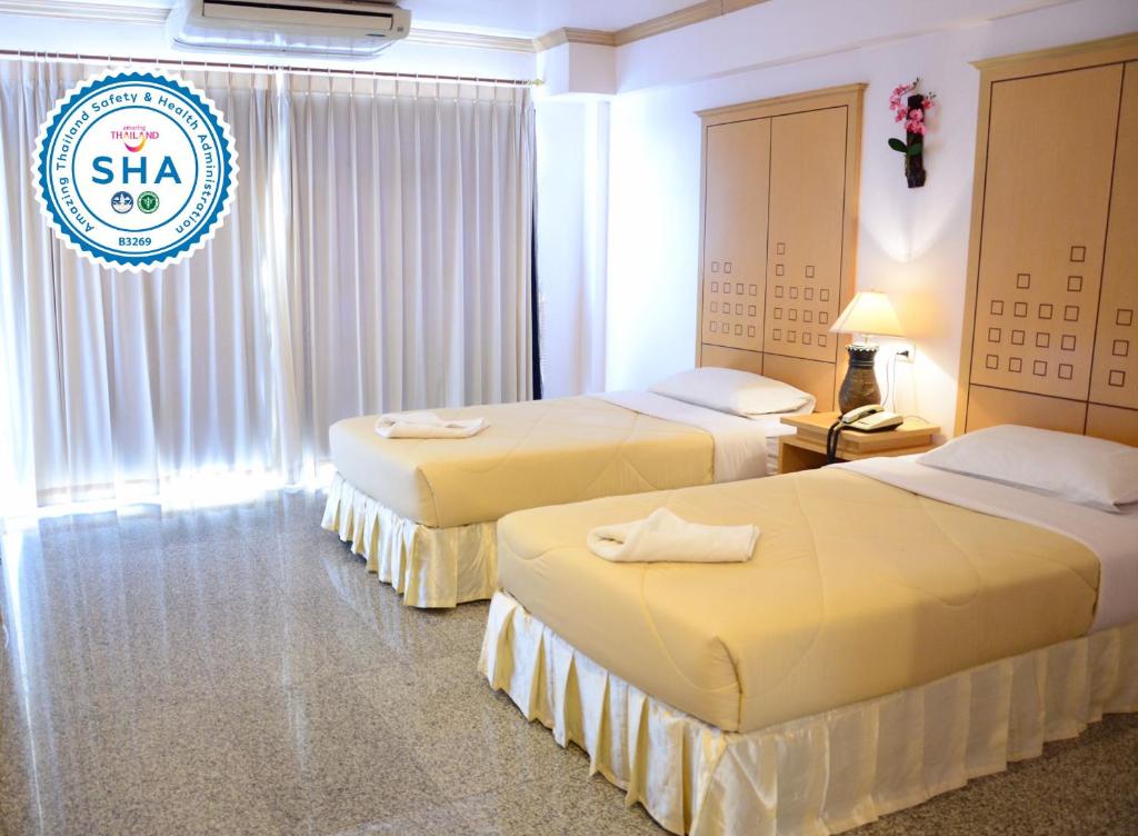素辇府Maneerote Hotel的酒店客房设有三张床,标有sla的标志