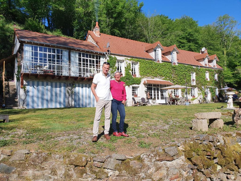 un hombre y una mujer parados frente a una casa en Moulin De Sardeix ( De Cottage ), en Chéniers