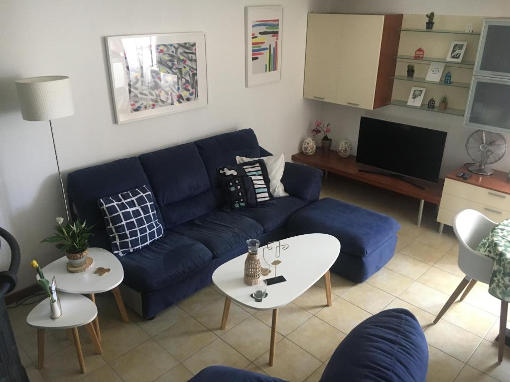 a living room with a blue couch and a table at apartmentsIT vista mare in Alba Adriatica