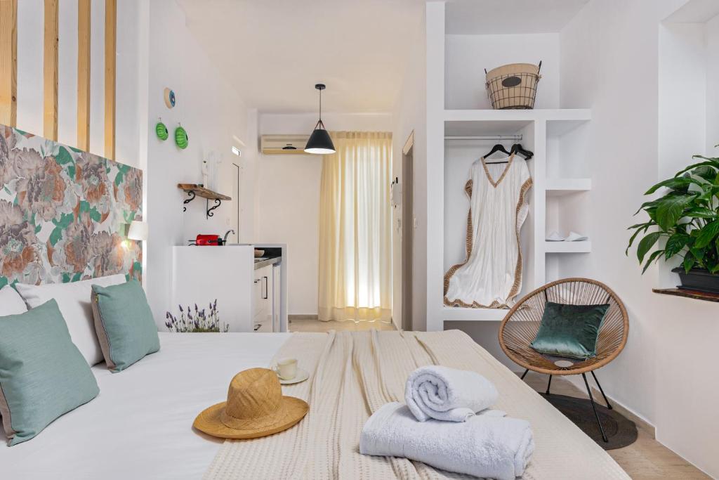een slaapkamer met een bed met een hoed en handdoeken bij Eora Studios in Laganas