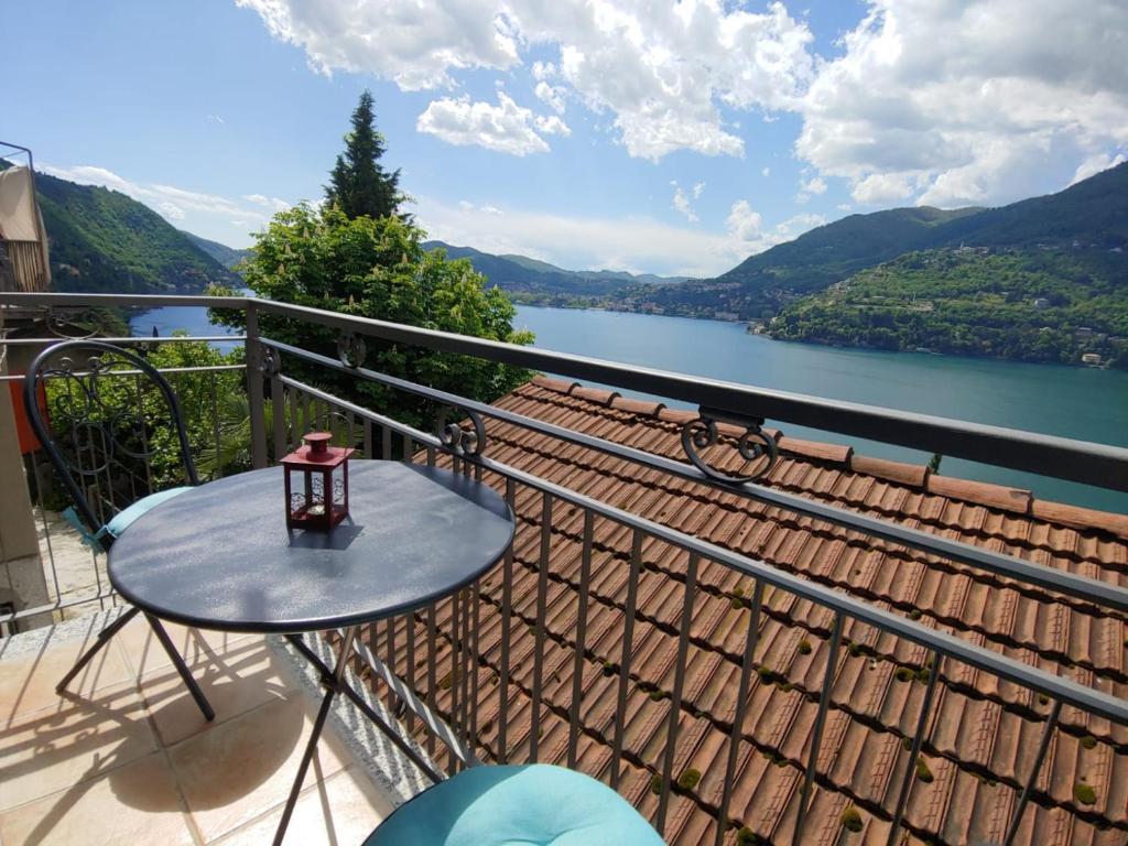 una mesa en un balcón con vistas al lago en CasAle sul Lago di Como, en Blevio