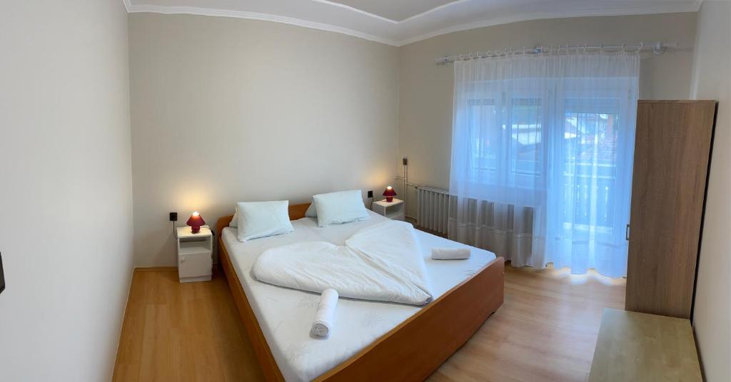 Postel nebo postele na pokoji v ubytování Pingvin Cukrászda Apartman felső szint