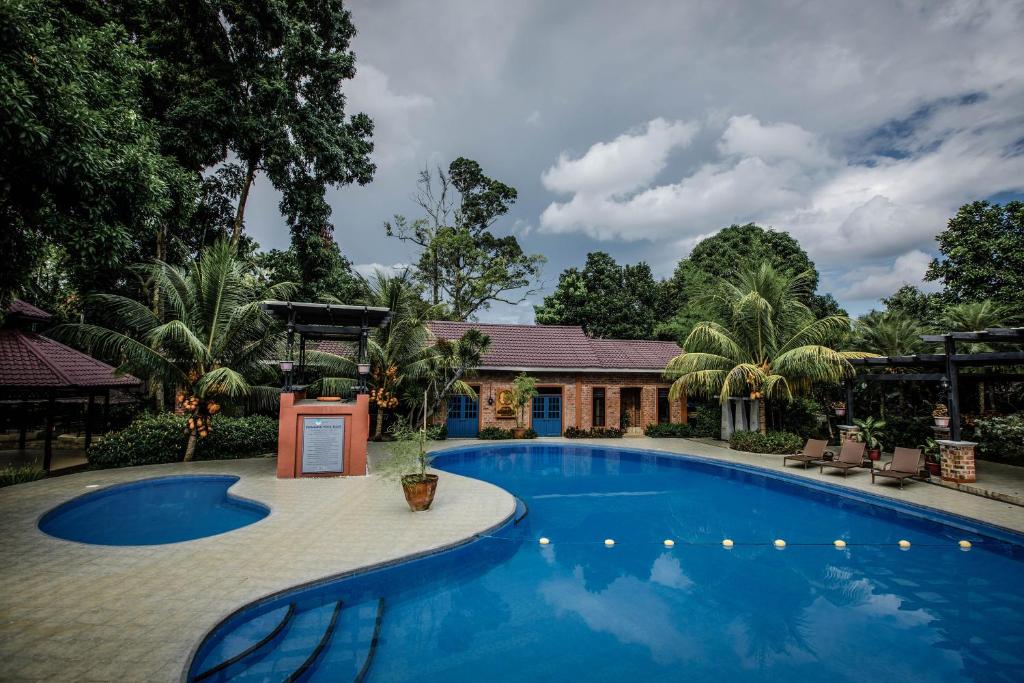 a swimming pool in front of a house at Malagos Garden Resort in Davao City