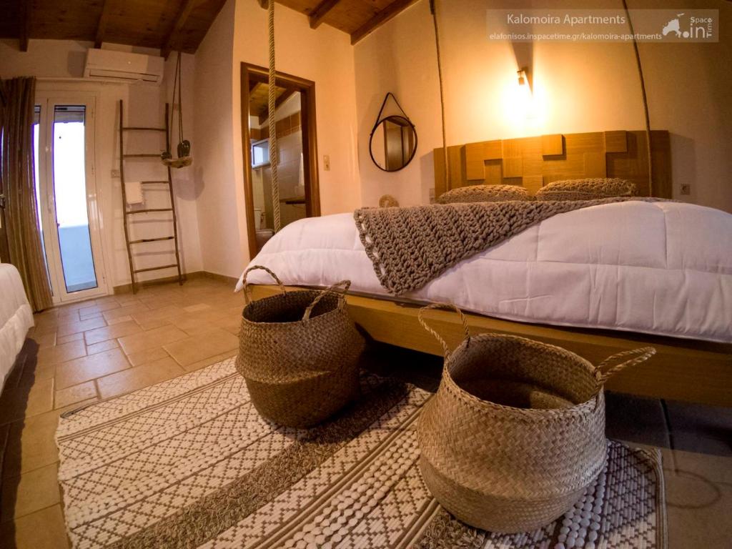 a bedroom with a bed with baskets on the floor at Kalomoira's Apartments in Elafonisos