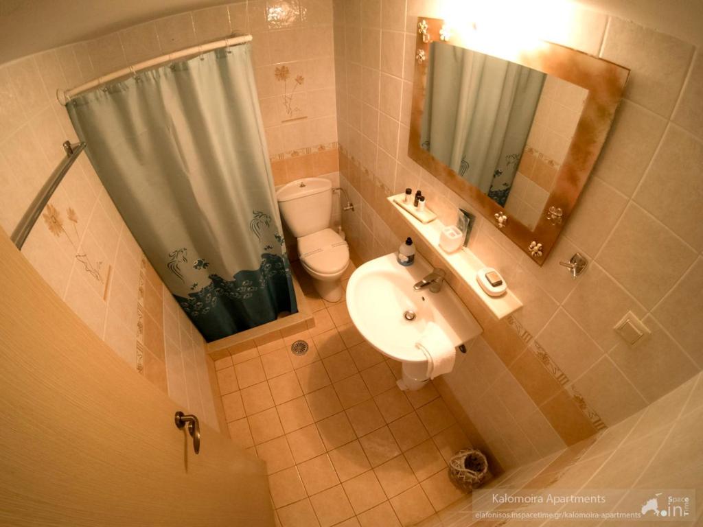 エラフォニソスにあるKalomoira's Apartmentsの洗面台、トイレ、鏡のあるバスルーム