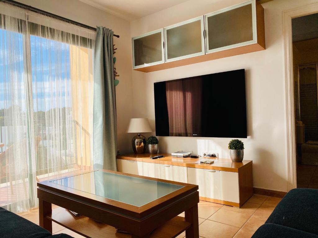a living room with a tv and a coffee table at Can Blau Formentera Apartamento in Es Pujols