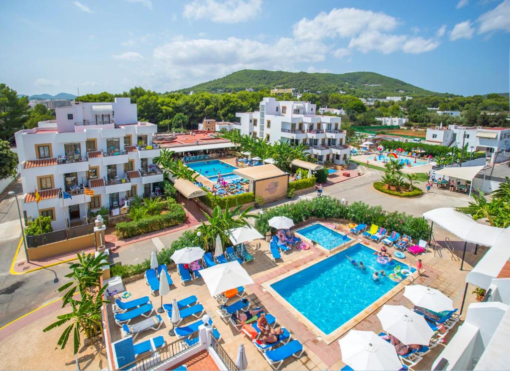
a hotel room with a pool and lawn chairs at Casa Luis Apartments in Santa Eularia des Riu
