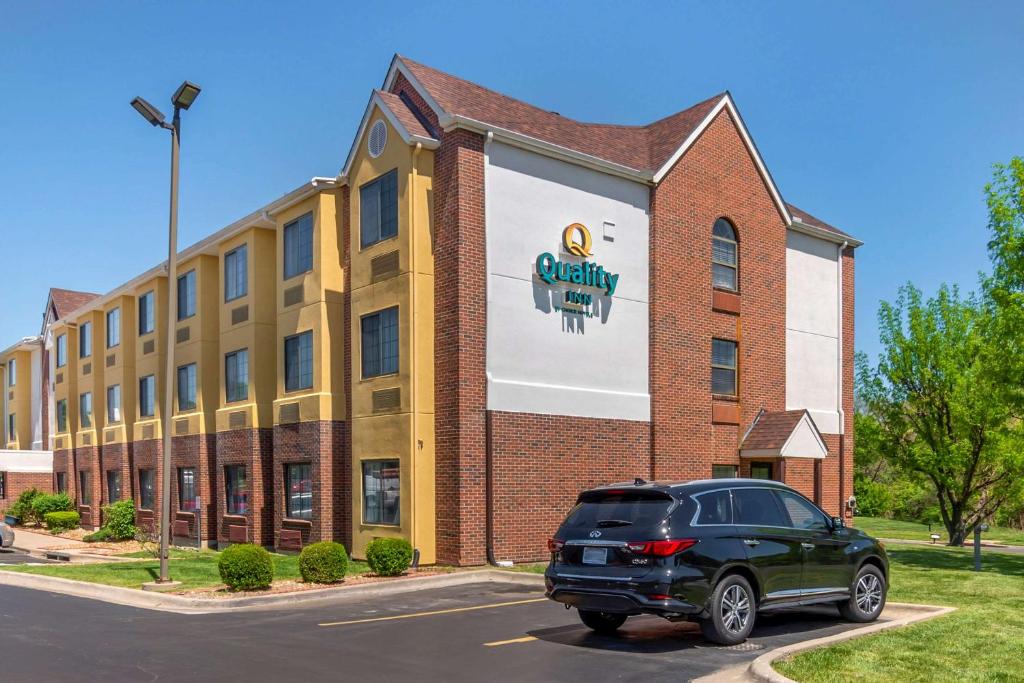 uma SUV preta estacionada em frente a um edifício de tijolos em Quality Inn Overland Park Kansas City em Overland Park