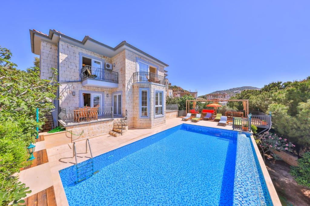 a house with a swimming pool in front of it at Villa Günbatımı in Kaş
