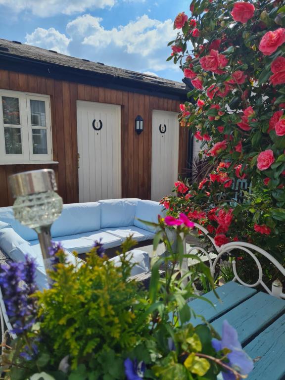 un patio con un sofá azul y algunas flores en The Pelican Inn, en Devizes