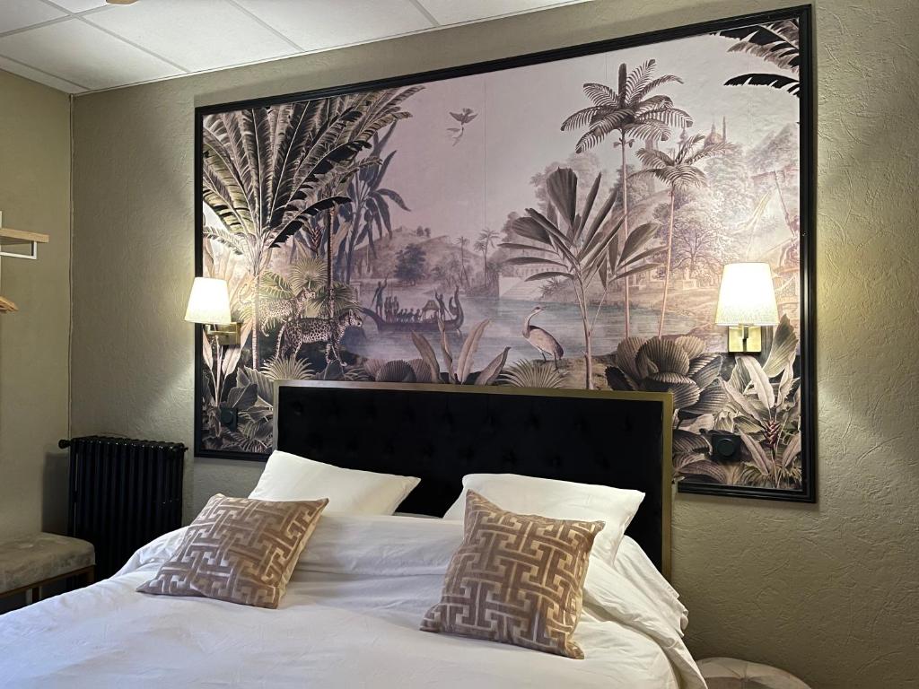 a bedroom with a large painting above a bed with pillows at Coco Marco Hôtel in Nyons