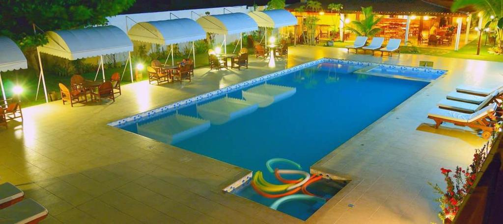 una piscina por la noche con piscina en Pousada Guaratiba, en Prado