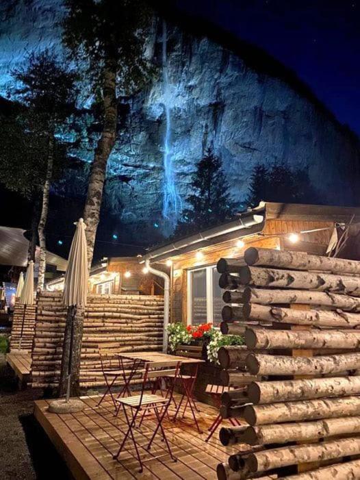 a house with a table and chairs and a mountain at Camping Jungfrau in Lauterbrunnen