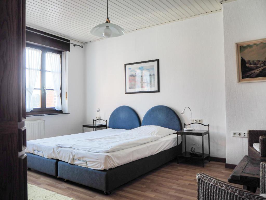 a bedroom with a large bed with blue chairs at Mutter Siepe in Lüdinghausen