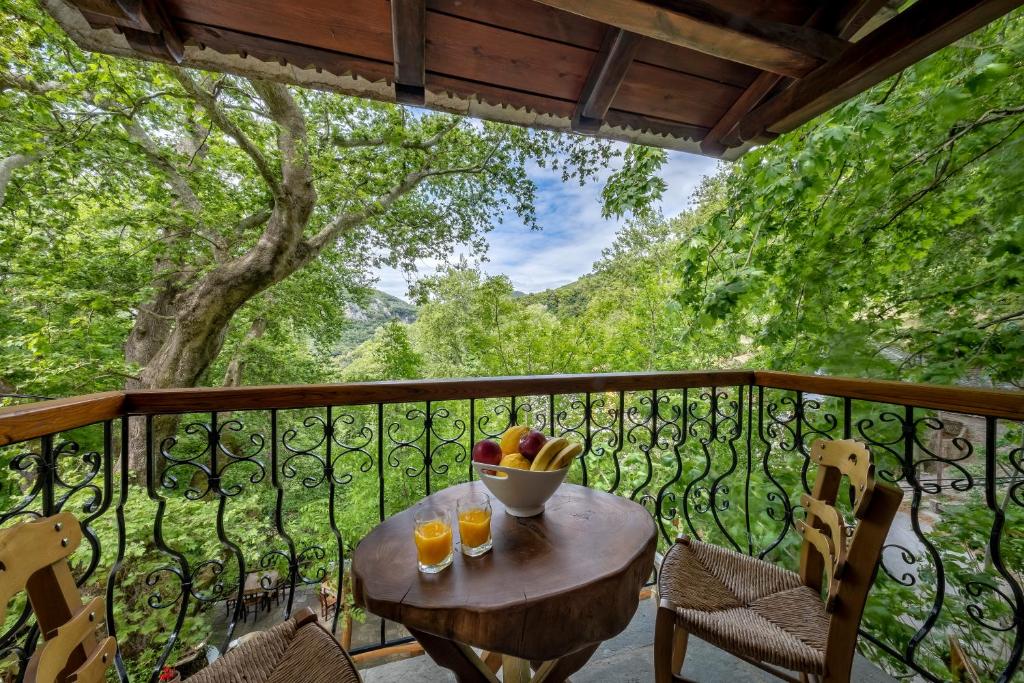 a table on a balcony with a bowl of fruit at Palios Stathmos in Mileai