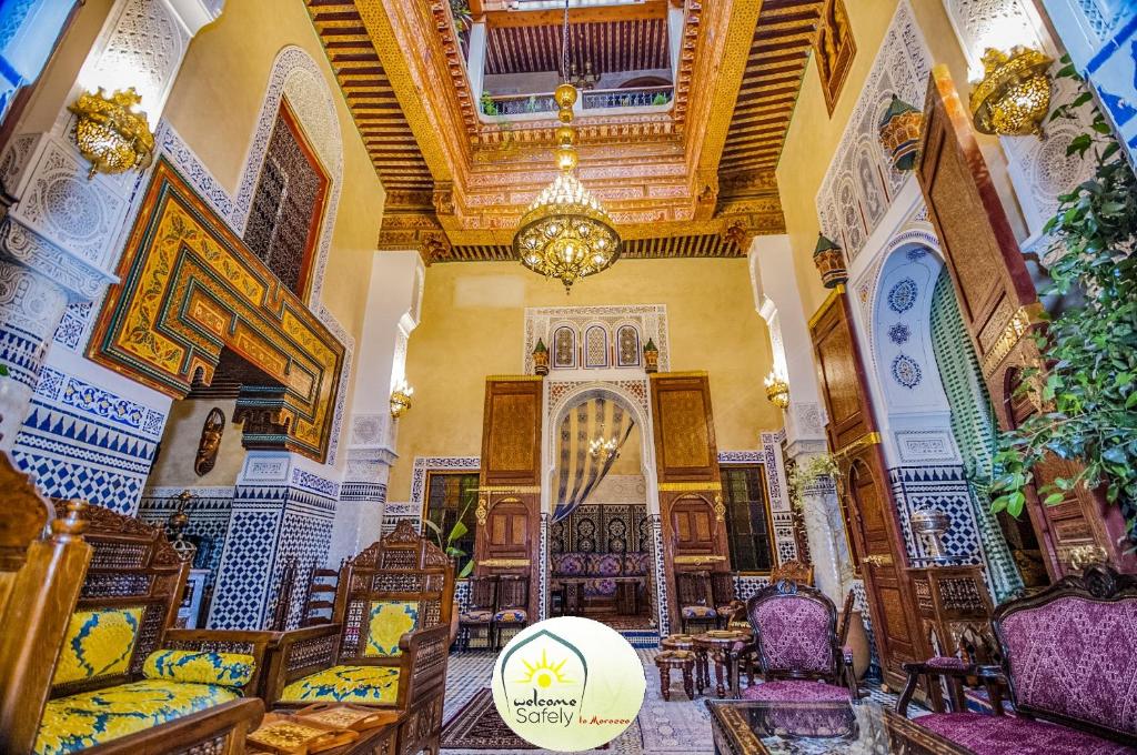 a large room with a chandelier and chairs in a building at Riad Mama H&K in Meknès