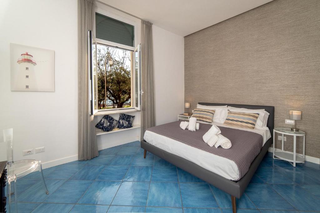 una camera con un letto con pavimenti blu e una finestra di Suitesettepesciolini - Case vacanze Nemo e Dory a Salerno