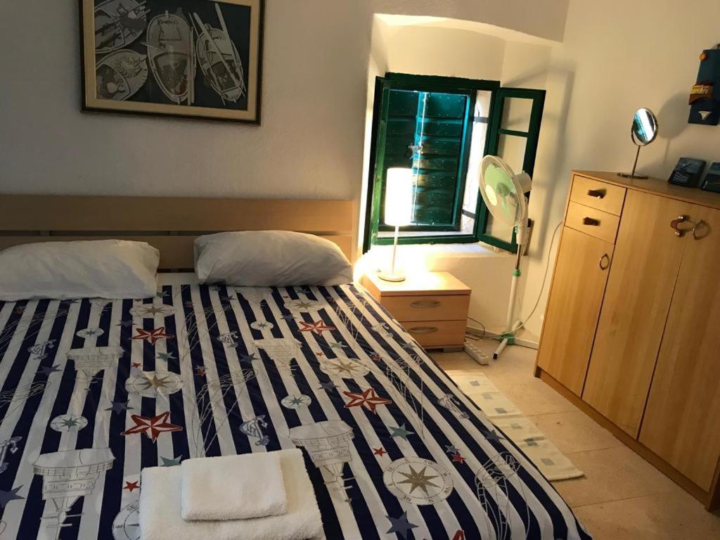 a bedroom with a bed with a striped blanket at House Beatrix in Stari Grad