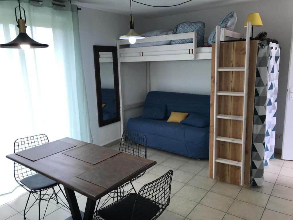 uma sala de estar com uma mesa de jantar e um beliche em appartement studio em Prayssac