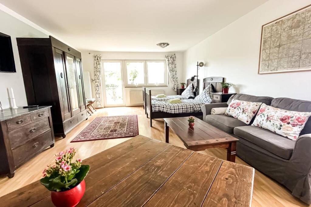 uma sala de estar com um sofá e uma mesa em Apartment am Auensee mit großer Terrasse, Grill und Privat-Parkplatz em Leipzig