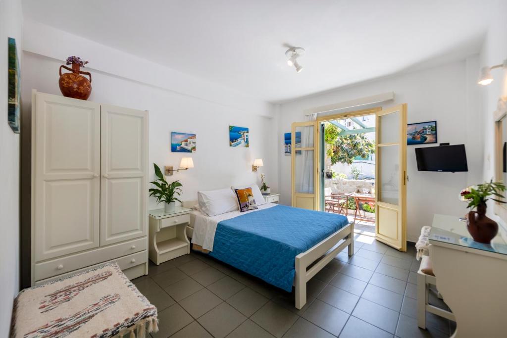 a bedroom with a blue bed and a balcony at Margarita Studios in Parikia