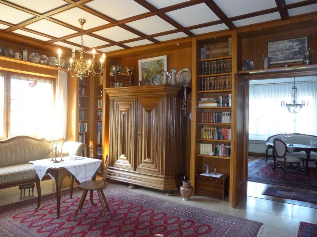 a living room with a couch and a table and bookshelves at Burghotel in Rothenburg ob der Tauber