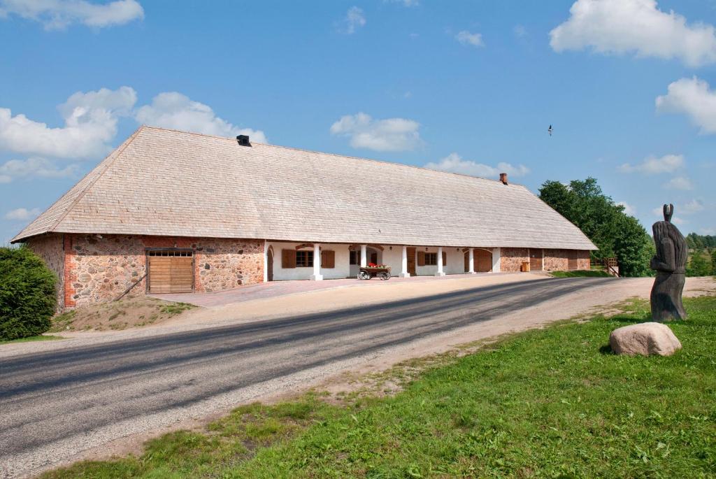 a barn with a statue next to a road at Vastseliina Piiskopilinnus 