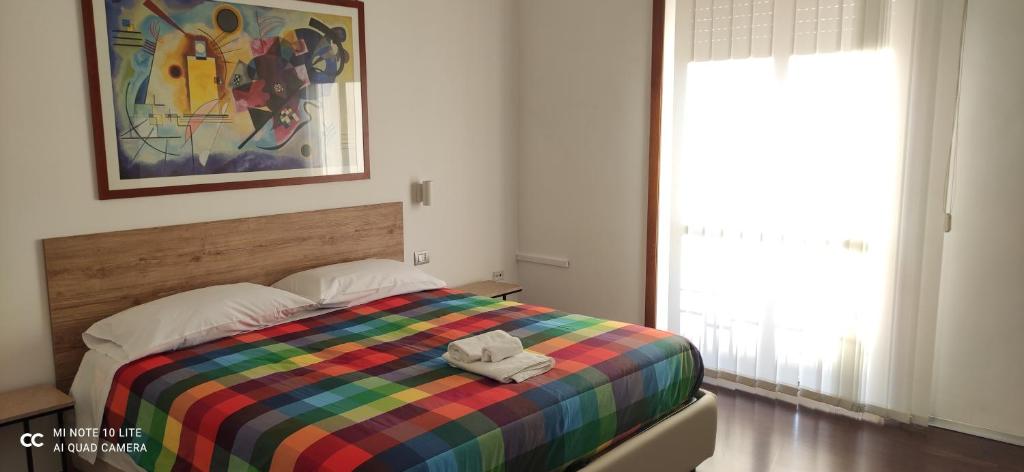 - une chambre dotée d'un lit coloré avec un chapeau dans l'établissement COSENZAGUESTHOUSE, à Cosenza