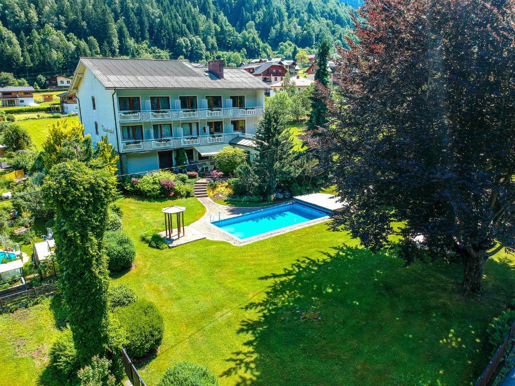 vista aerea su una casa e su un cortile con piscina di Klamberghof Burgstaller a Feld am See