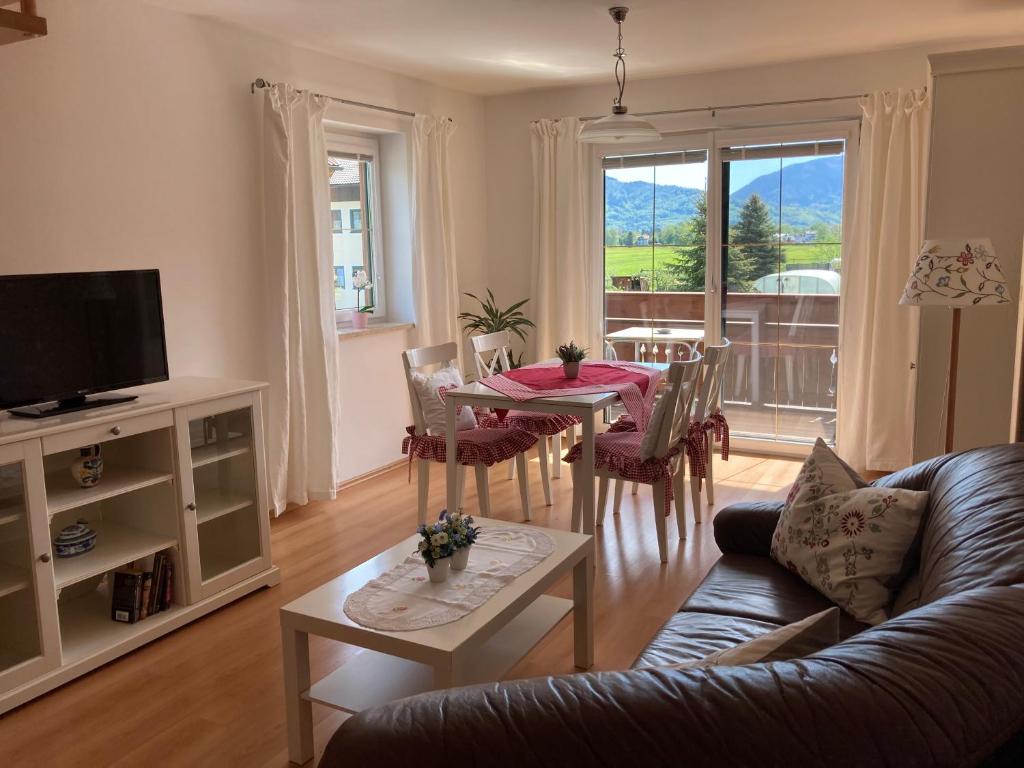 ein Wohnzimmer mit einem Tisch und einem Sofa in der Unterkunft Ferienwohnung Schmiedhansl Moos in Salzburg