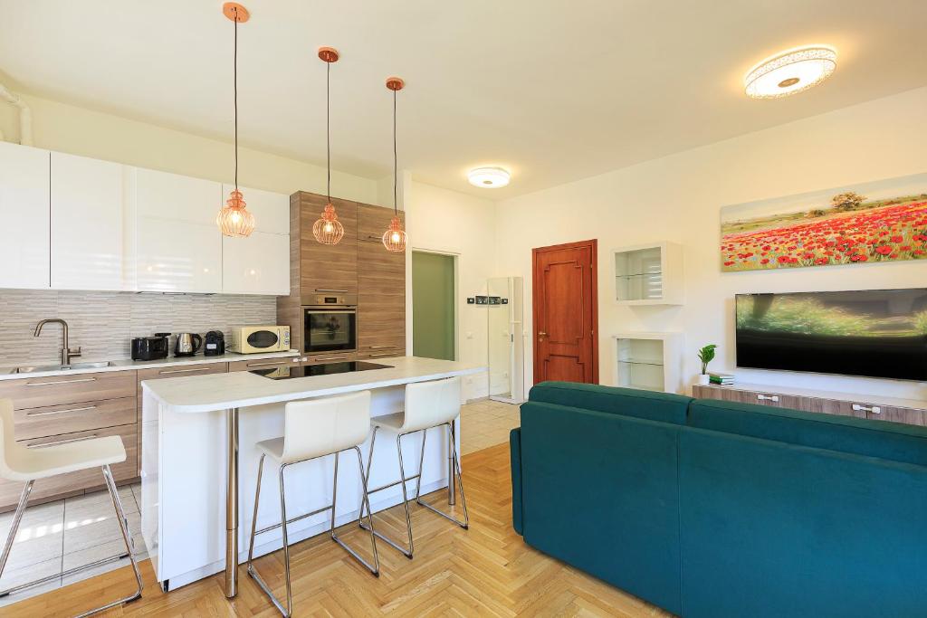 kuchnia z niebieską kanapą i wyspą kuchenną w obiekcie Casa Nives - By Impero House w mieście Stresa