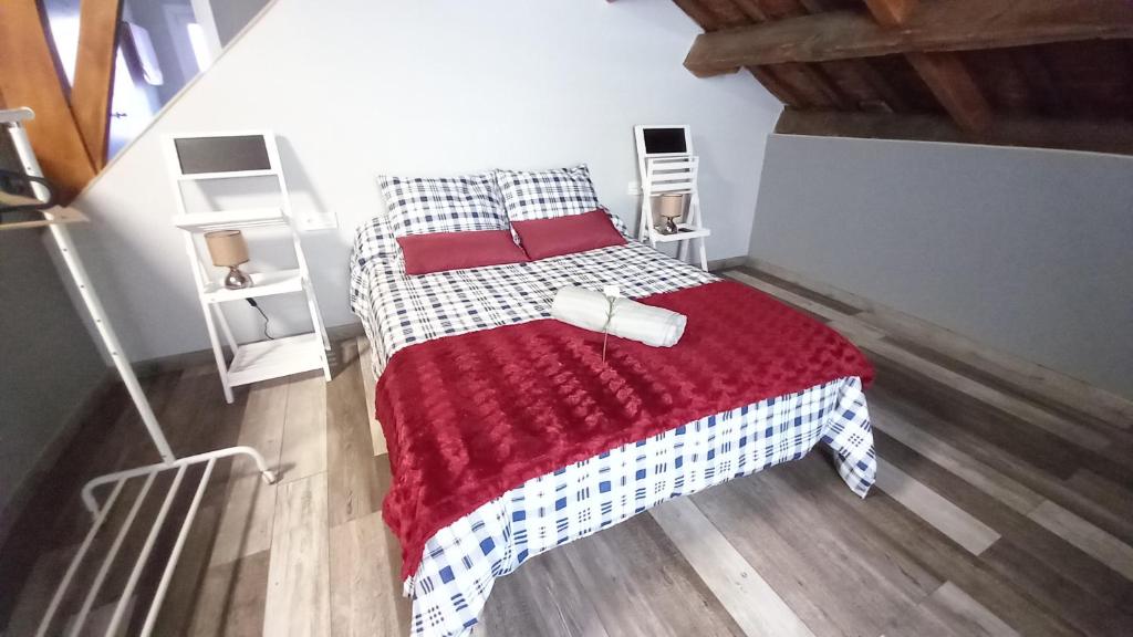 1 dormitorio con 1 cama con manta roja y blanca en APS Valdés de Avilés, en Avilés