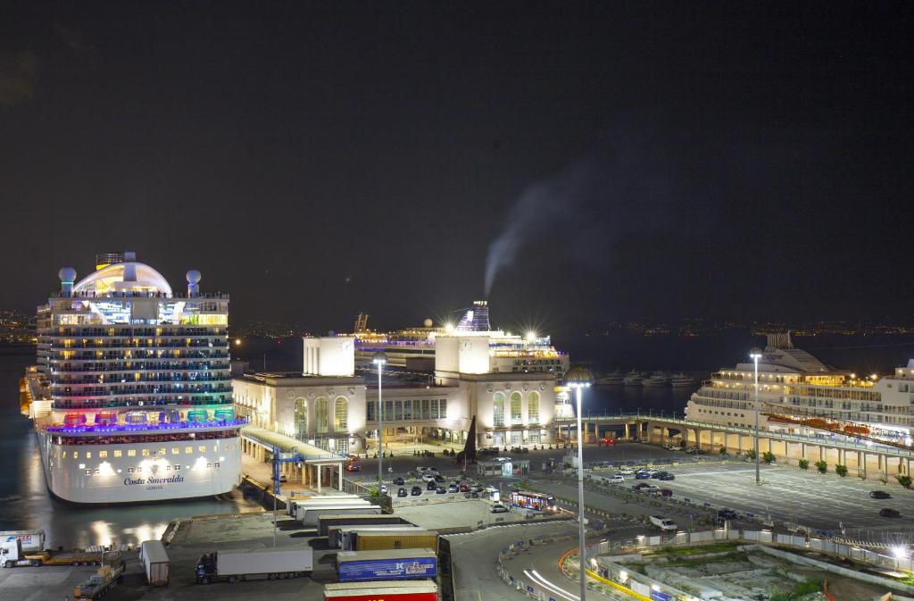 un crucero está atracado en una ciudad por la noche en Six Rooms en Nápoles